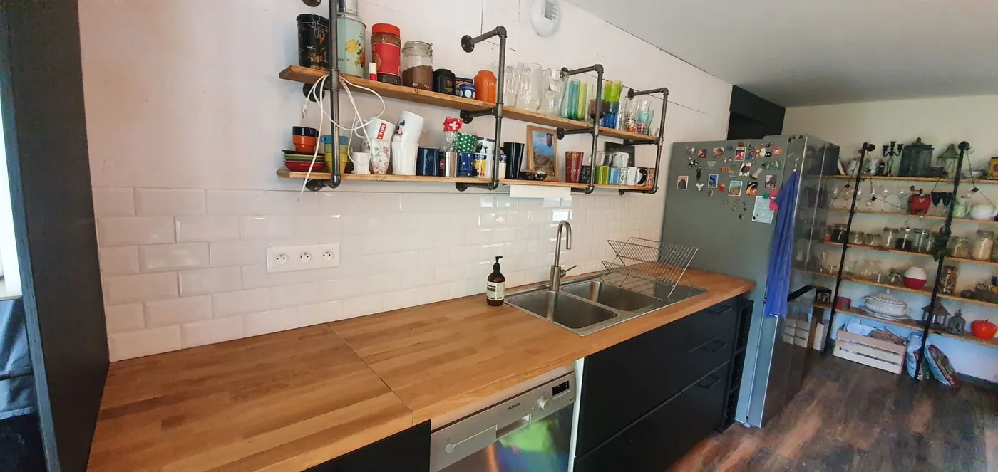 Cuisine verte avec crédence en carrelage métro et plan de travail bois